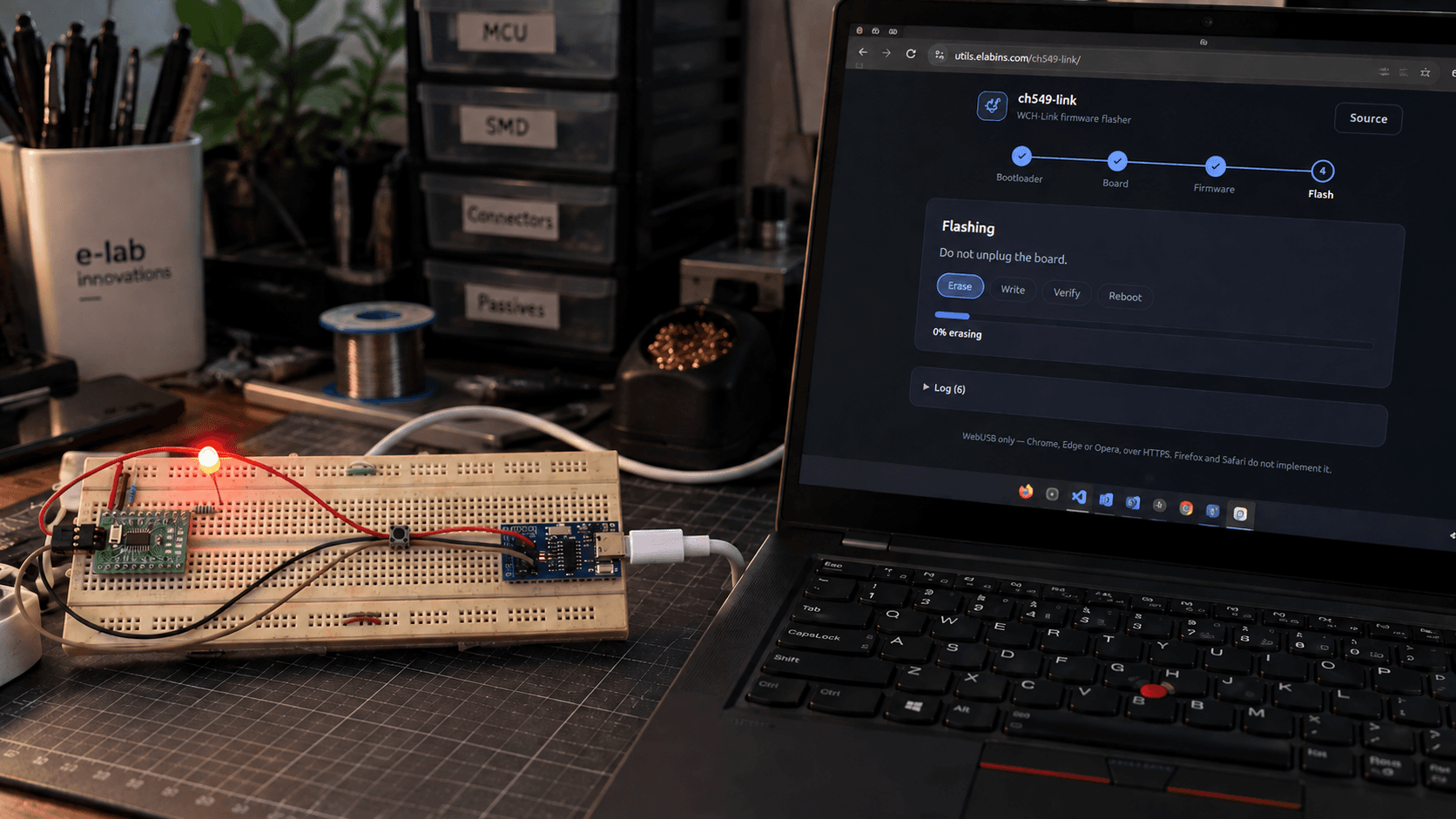 A CH32V003 on a breadboard with a lit LED, wired to a WCH-Link clone, beside a laptop running the ch549-link web flasher mid-erase